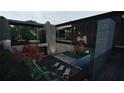 Expansive outdoor living space with modern lounge chairs, lush greenery, and an elegant reflecting pool in a modern house at 2413 Spalding Dr, Atlanta, GA 30350