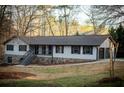 Beautiful home with white siding, dark shutters, stone foundation, and attached garage with a well-maintained lawn at 2923 Glenhaven Sw Ct, Conyers, GA 30094