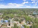 Aerial view of a neighborhood with tree-lined streets, showcasing the homes nestled amongst lush greenery and a nearby lake at 465 Hunt River Way, Suwanee, GA 30024