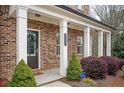 Charming brick home featuring a covered porch with white columns and landscaped front yard at 2026 Forte Ln, Alpharetta, GA 30009
