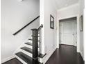 Entryway featuring a staircase with dark wood railing and hardwood floors at 2026 Forte Ln, Alpharetta, GA 30009