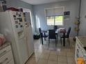 Bright kitchen featuring a dining area with tiled flooring and a white refrigerator at 3657 Willow Wood Way, Lawrenceville, GA 30044