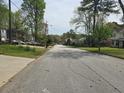 A peaceful neighborhood street lined with mature trees and sidewalks, providing a serene setting at 3657 Willow Wood Way, Lawrenceville, GA 30044
