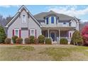 Attractive two-story home with a welcoming front porch and landscaped yard, showcasing curb appeal at 1130 Martins Chapel Rd, Lawrenceville, GA 30045