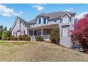 Inviting two-story house featuring charming front porch and manicured lawn on a sunny day at 1130 Martins Chapel Rd, Lawrenceville, GA 30045