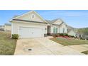 Well-maintained home featuring a two-car garage, stone accents, and a landscaped yard with colorful flower beds at 1640 Andalusian Way, Conyers, GA 30012