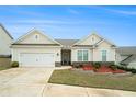 Well-maintained single-story home featuring a two-car garage, landscaped yard with flower beds, and stone accents at 1640 Andalusian Way, Conyers, GA 30012