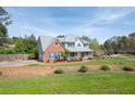 Spacious home with a large yard, covered porch, and a charming mix of brick and siding at 3174 Country Club Nw Ct, Kennesaw, GA 30144