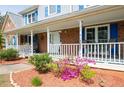 Inviting front porch with cozy seating, decorative accents, and flowering plants at 3174 Country Club Nw Ct, Kennesaw, GA 30144