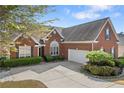 Red brick home with an attached garage and a well-maintained lawn at 3503 Dunbar Ln, Suwanee, GA 30024
