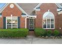 Close up of the brick facade entrance with tidy landscaping and a beautiful arched window above door at 3503 Dunbar Ln, Suwanee, GA 30024