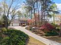 Beautiful brick home featuring an inviting driveway and a serene, wooded landscape at 3824 Running Fox Dr, Marietta, GA 30062