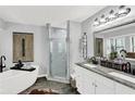 Bathroom with double vanities, soaking tub, and glass shower, showcasing modern design at 2806 Peachtree Walk, Duluth, GA 30096