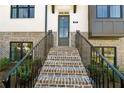 Inviting townhome entrance featuring brick stairs, iron railings, and a modern glass-paneled front door at 2822 Evanshire Ave # 111, Duluth, GA 30096
