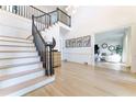 Bright foyer with hardwood floors, a staircase with dark rails, and an open view to the living room at 85 Cliffside Crossing, Atlanta, GA 30350