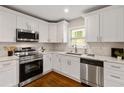 Modern kitchen with stainless steel appliances, white cabinetry, and subway tile backsplash at 2297 Sheryl Dr, Decatur, GA 30032
