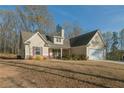 Traditional home featuring a two-car garage, well-maintained lawn, and covered front porch at 338 Rc Thompson Rd, Dallas, GA 30157