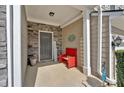Inviting front porch with stone accents, a red bench and a quaint 