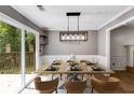 Dining room with sliding glass door to deck, and a modern light fixture at 4558 Dorsett Shoals Ct, Douglasville, GA 30135