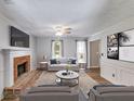 Cozy living room with brick fireplace, ceiling fan, and neutral decor at 4558 Dorsett Shoals Ct, Douglasville, GA 30135