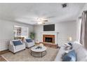 Comfortable living room with a brick fireplace, ceiling fan, and large window at 4558 Dorsett Shoals Ct, Douglasville, GA 30135