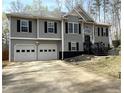 Inviting two-story home featuring a two-car garage, gray siding, and a landscaped front yard on a sunny day at 1380 Cedar Hl, Douglasville, GA 30134