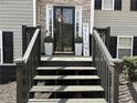 Close-up of the front porch with a black front door, decorative plants, and a 'Welcome' sign at 1380 Cedar Hl, Douglasville, GA 30134