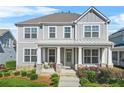 Inviting home featuring a classic covered porch and a well-manicured lawn at 9893 Colchester St, Douglasville, GA 30135