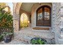 Close up of the brick arched entryway with brick stairs and double wooden front doors at 425 Prestwick Ct, Alpharetta, GA 30005