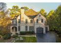 Beautiful two-story brick home with a manicured lawn, arched entryway, and attached two-car garage at 425 Prestwick Ct, Alpharetta, GA 30005