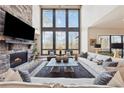 Bright living room with soaring windows, stone fireplace, and stylish furniture at 13415 Bishops Ct, Roswell, GA 30075