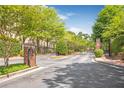 Elegant entrance gate with brick columns and mature trees on a paved road at 3635 E Paces Ne Cir # 1308, Atlanta, GA 30326