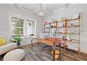 Bright and airy home office with custom shelving, a cozy window seat, wood-look floors, and modern decor at 4025 Bullock Bridge Rd, Loganville, GA 30052