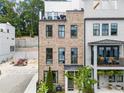 Charming brick townhouse with black framed windows, a balcony, and a landscaped front yard at 1770 Beckham Ne Pl # 47, Atlanta, GA 30324