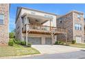 Two-story home with a deck above the garages, overlooking the backyard and a clear blue sky at 1867 Sterling Chase, Buford, GA 30518