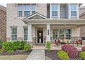 Inviting front porch with brick columns, seating area, and well-maintained landscaping at 1867 Sterling Chase, Buford, GA 30518