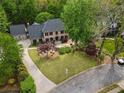 Aerial view of brick home showcasing a well-manicured lawn and long driveway at 3646 Sope Creek Farm Se, Marietta, GA 30067