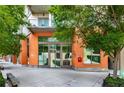 Modern building exterior featuring an orange facade, large windows, lush greenery, and inviting street access at 1100 Howell Mill Nw Rd # 711, Atlanta, GA 30318