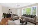 Staged living room with neutral tones, hardwood floors, and large windows providing natural light at 1910 Thompson Ave, East Point, GA 30344