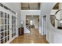 Grand foyer with hardwood floors, soaring ceilings, elegant lighting, and an open staircase with iron spindles at 4880 Stone Moss Path, Hoschton, GA 30548