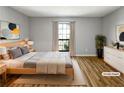 This light-filled bedroom features wood floors, a large window, and neutral décor at 4640 Vinings Central Se Run # 128, Atlanta, GA 30339