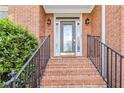 Inviting front porch with brick steps and iron railings, perfect for enjoying the outdoors at 1142 Hidden Spirit Trl, Lawrenceville, GA 30045