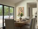 Sunlit dining room with a wood table, modern chairs, and views of the backyard at 541 Earlvine Nw Way, Kennesaw, GA 30152