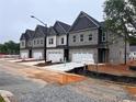 New townhomes feature brick and siding exteriors with attached garages under a cloudy sky at 3108 Marbella Cir # 4, Kennesaw, GA 30152