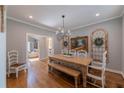 Bright dining room with light wood table, chandelier, hardwood floors, and access to living area at 622 Goldpoint Trce, Woodstock, GA 30189