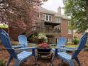 Beautiful backyard with blue Adirondack chairs, fire pit, and blooming trees at 1956 Grace Arbor Ne Ct, Atlanta, GA 30329