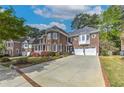 Charming brick home featuring a long driveway and a well-manicured lawn with colorful flowerbeds at 1956 Grace Arbor Ne Ct, Atlanta, GA 30329