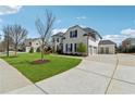 Spacious home with a long driveway, three-car garage, green lawn, and basketball hoop at 214 Leland Way, Woodstock, GA 30188