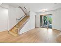 Bright foyer with hardwood floors, staircase, and modern light fixture at 402 Chattahoochee St, Roswell, GA 30075