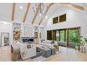 Bright, spacious living room features vaulted ceilings, exposed beams, fireplace, and large windows overlooking the backyard at 402 Chattahoochee St, Roswell, GA 30075